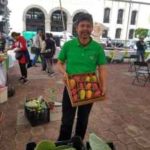 Agricultor mexicano mostrando caixa de frutas.