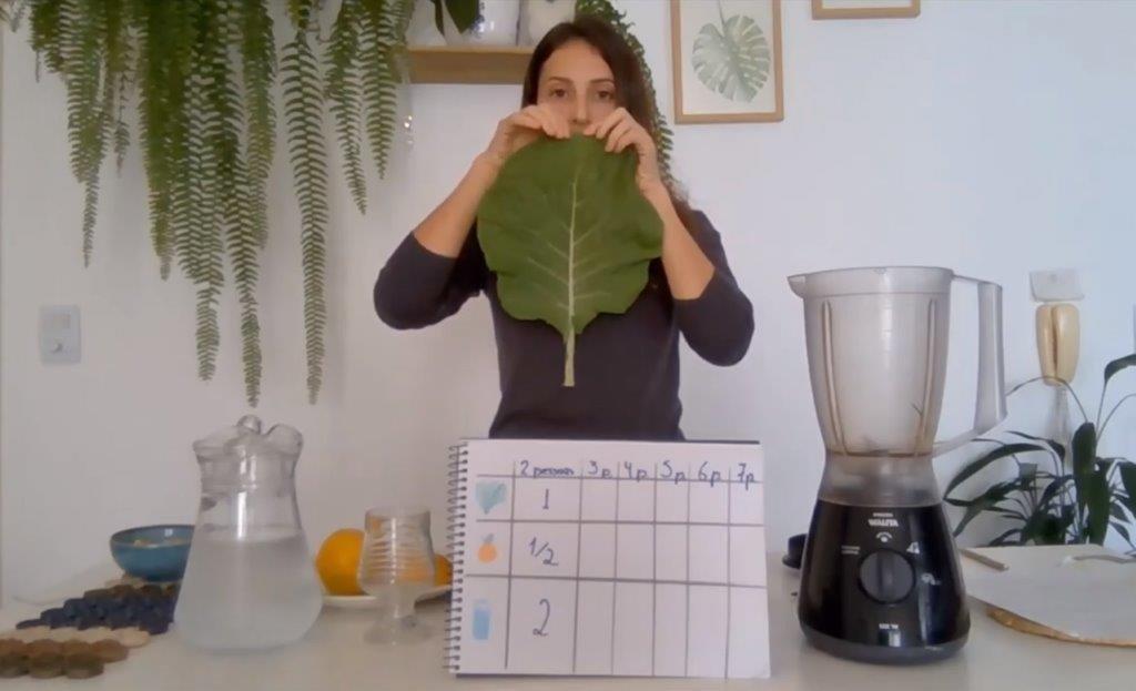 Imagem capturada a partir de videoaula, onde Karina ensina sobre frações quanto parte uma folha de couve ao meio.