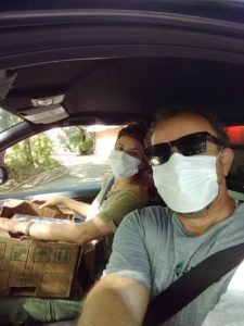 Foto dos técnicos do Cepagro, Isadora e Charles, dentro do carro a caminho das entregas da ação solidária.