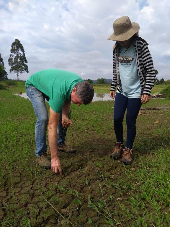 Agricultor e técnica de campo do Cepagro analisando o solo.